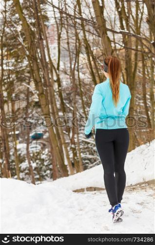 Girl jogging in frozen park, running among snow and trees, health fitness nature fashion concept. . Girl jogging in frozen park
