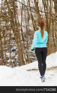 Girl jogging in frozen park, running among snow and trees, health fitness nature fashion concept. . Girl jogging in frozen park