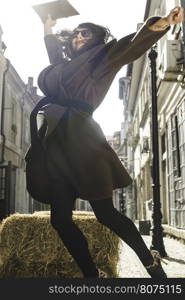 Girl jump on a street. Brown jacket.