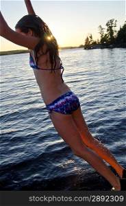 Girl jumping into a lake, Lake of the Woods, Ontario, Canada