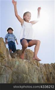Girl jumping off boulder outdoors