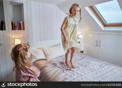Girl jumping on bed in loft room