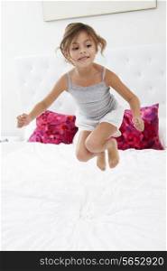 Girl Jumping On Bed Wearing Pajamas