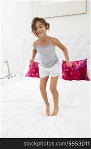 Girl Jumping On Bed Wearing Pajamas