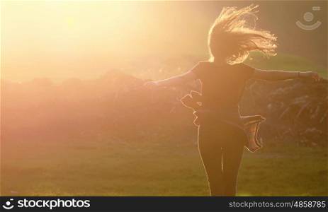 Girl jumping up in a beautiful sunset setting
