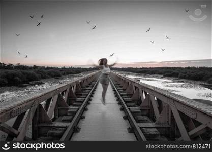 girl jumps on bridge surrounded by birds in the evening mystery. girl jumps on bridge surrounded by birds in the evening
