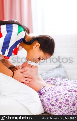Girl kissing her boyfriend who laying on sofa&#xA;