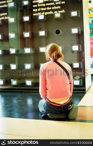 Girl kneeling in art gallery