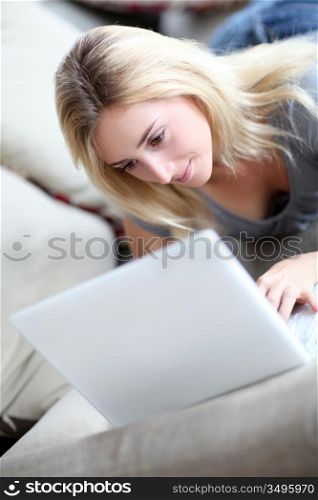 Girl laying in sofa with laptop computer