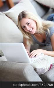 Girl laying in sofa with laptop computer