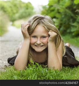Girl laying on grass in dirt path