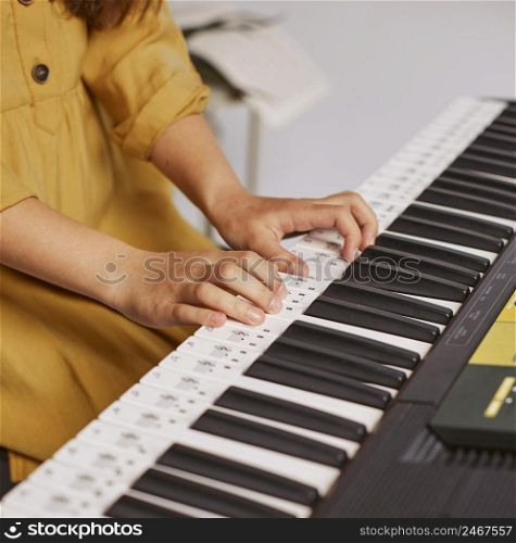 girl learning how play electronic keyboard