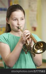 Girl Learning To Play Trumpet In School Music Lesson