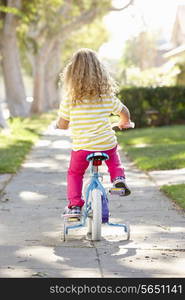 Girl Learning To Ride Bike On Path