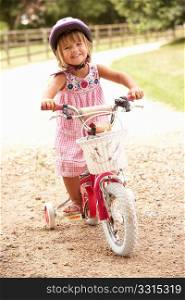 Girl Learning To Ride Bike Wearing Safety Helmet