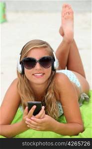 Girl listening to music on the beach