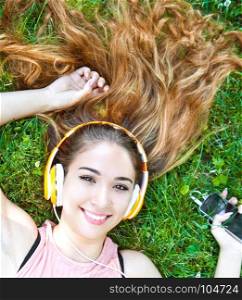 Girl listening to music streaming with headphones in summer