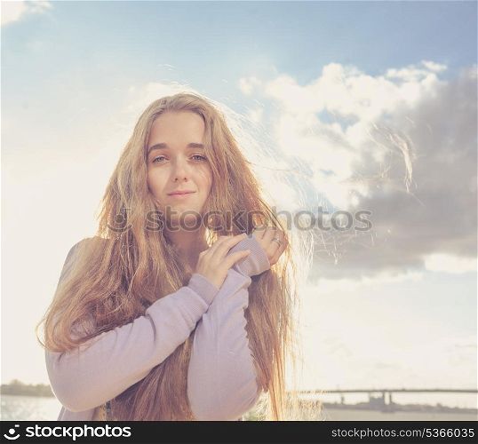 Girl looking at camera. Portrait of happy young female against clear sky