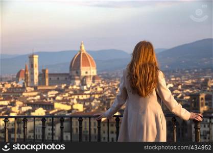 girl looking at the city of Florence from the viewpoint on the dawn