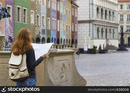 girl looking at the map standing at the main square Rynek of polish city Poznan