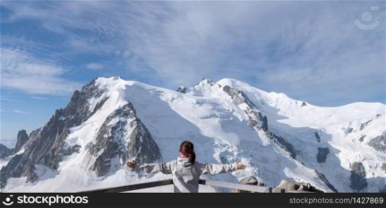 Girl looking at the mountains covered in snow in the French Alps, Chamonix.