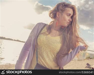 Girl looking away. Beautiful girl in the morning on the beach. Colorized cross process colored image