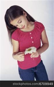 Girl looking down holding a flower