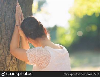 Girl looking out from tree. Rear view