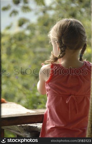 Girl looking out over balcony railing
