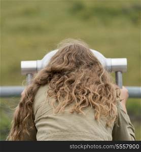 Girl looking through a coin-operated binoculars, Western Brook Pond, Norris Point, Gros Morne National Park, Newfoundland And Labrador, Canada