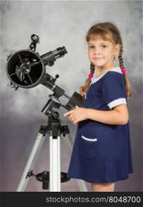 Girl lover of astronomy stands next to the telescope and looked into the frame