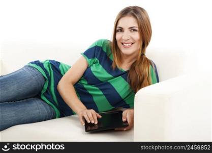 Girl lying on a sofa and using a tablet, isolated on white background