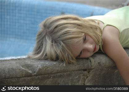 Girl lying on pool rim