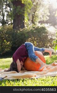 Girl lying on pumpkin