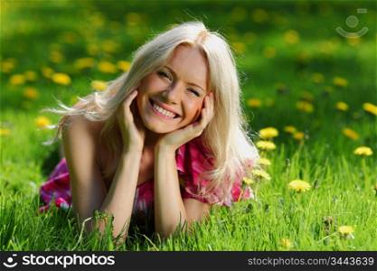 girl lying on the field of dandelions