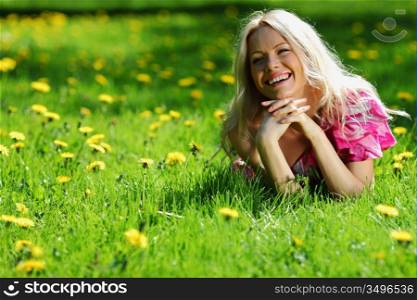 girl lying on the field of dandelions