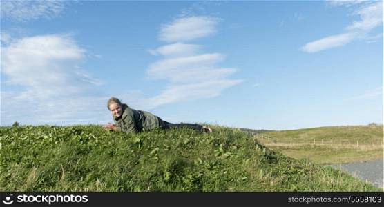 Girl lying on the grass, Witless Bay, Avalon Peninsula, Newfoundland And Labrador, Canada