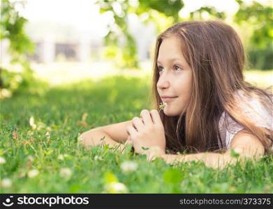 girl lying ona grass and holding a flower