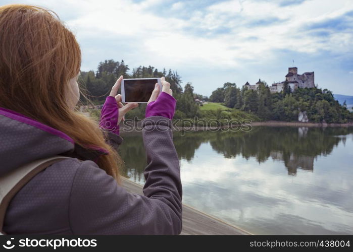 girl making a photo shoot of castle niedzica with the Smartphone, Poland