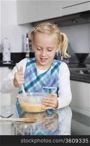 Girl making cookies in mixing bowl at kitchen