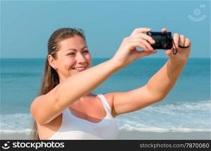 girl making self photo on a background of the sea