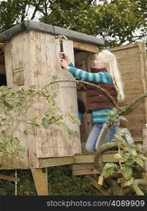 Girl mending treehouse