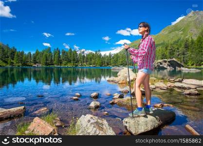 Girl near a colorful mountain lake during a mountain trekking in the summer