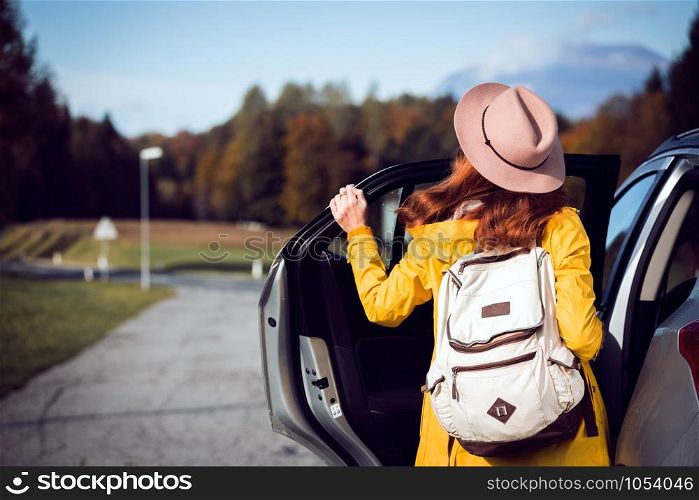 girl near the car and a beautiful mountain landscape in the background