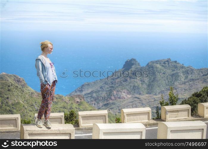 girl ocean Tenerife. He looks at the rocks in Beniho