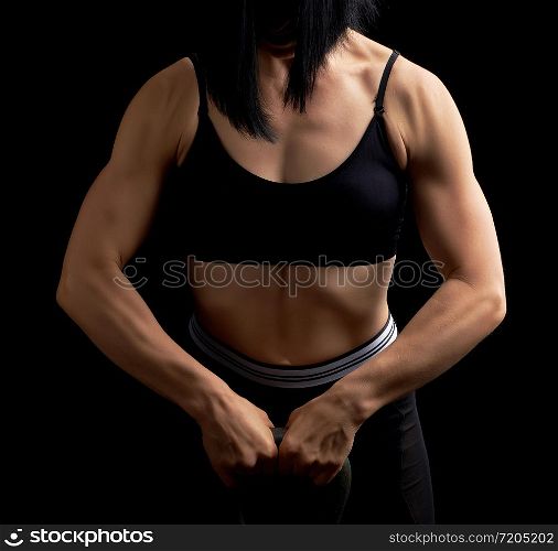 girl of athletic appearance holds an iron kettlebell in front of her, strength sports, low key