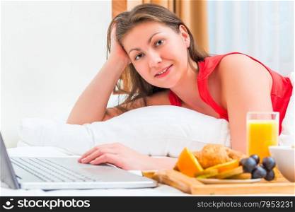 girl of European appearance with a laptop in bed