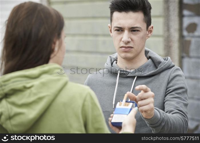 Girl Offering Teenage Boy Cigarette Outdoors