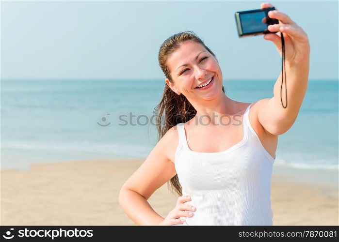 girl on a background of the sea with a small camera