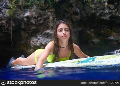 Girl on a surf board relaxed in Cenote sinkhole in Riviera Maya at mayan Mexico